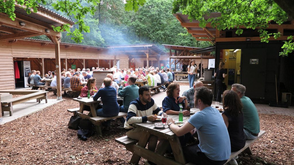 Groep aan de picknicktafels bij de barbecue op Landgoed Beukenrode
