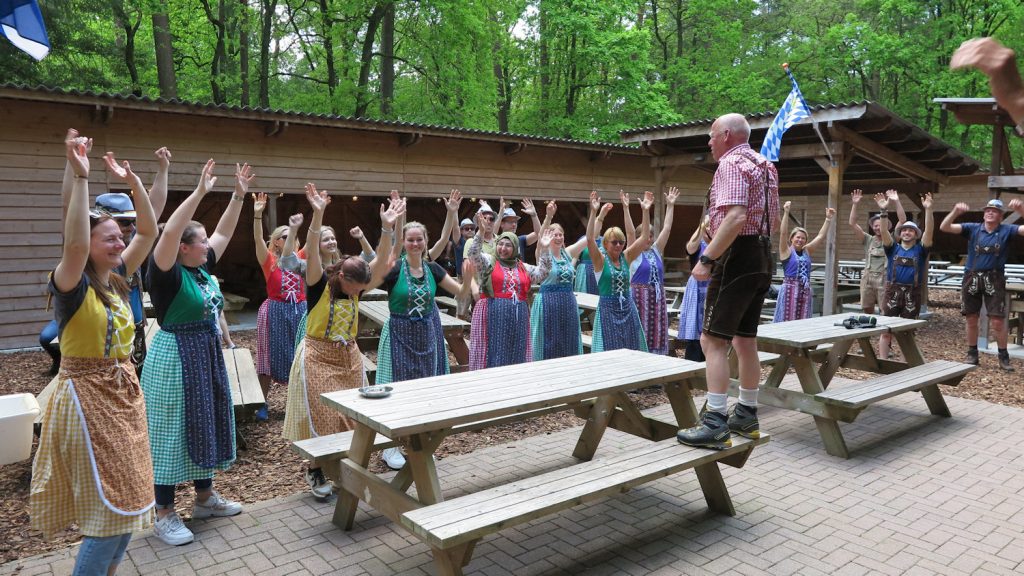 Groep in dirndls en lederhosen bij de Tiroler spelen